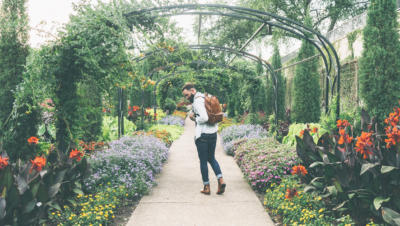 Man with backpack walking through garden